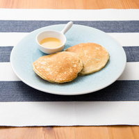 粉砂糖がかかったホットケーキとシロップの写真