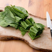 まな板の上のほうれん草と包丁の写真