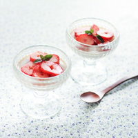 いちごとミントを飾ったガラスのプリンの写真