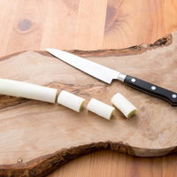 まな板の上の長ネギと包丁の輪切りの写真