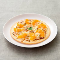 柑橘類とナッツを乗せたフルーツピザの写真