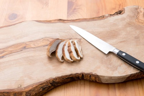 木の板の上でスライスされた椎茸と包丁