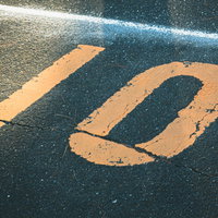 アスファルトに描かれたオレンジ色の駐車場番号10の写真