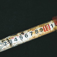 錆びて変色した古いメジャーと目盛り・金属製の測定工具の写真