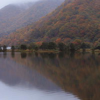 湖面に反射する秋元湖の紅葉、猪苗代町の静寂に包まれた秋の写真