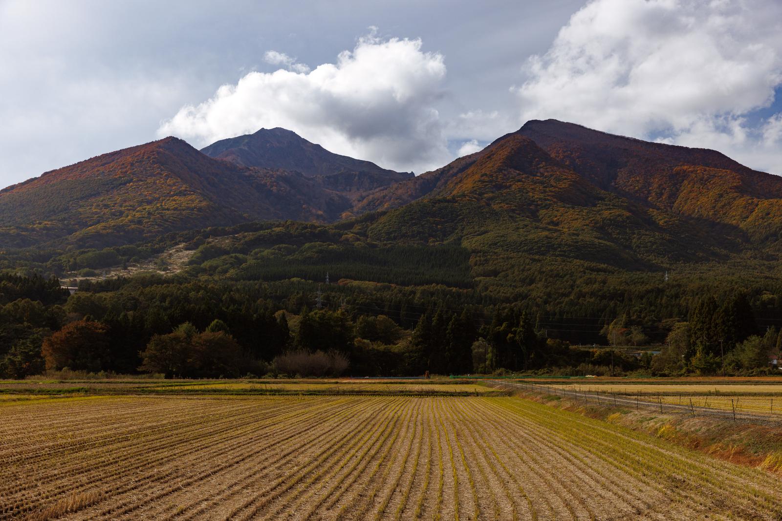 稲刈り後の耕地から見える紅葉の磐梯山と裏磐梯の山々