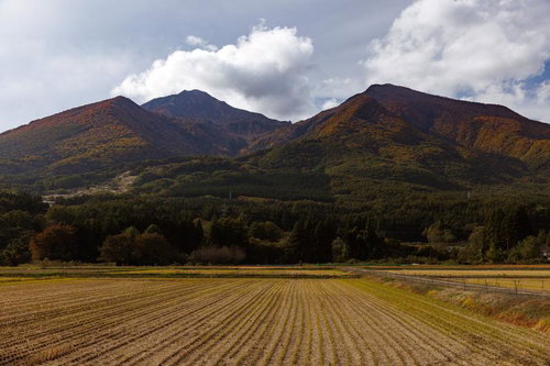 稲刈り後の田んぼの先に聳える紅葉の磐梯山と裏磐梯の山々