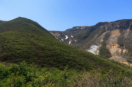 安達太良山の勢至平から眺める新緑と遠景の雪渓