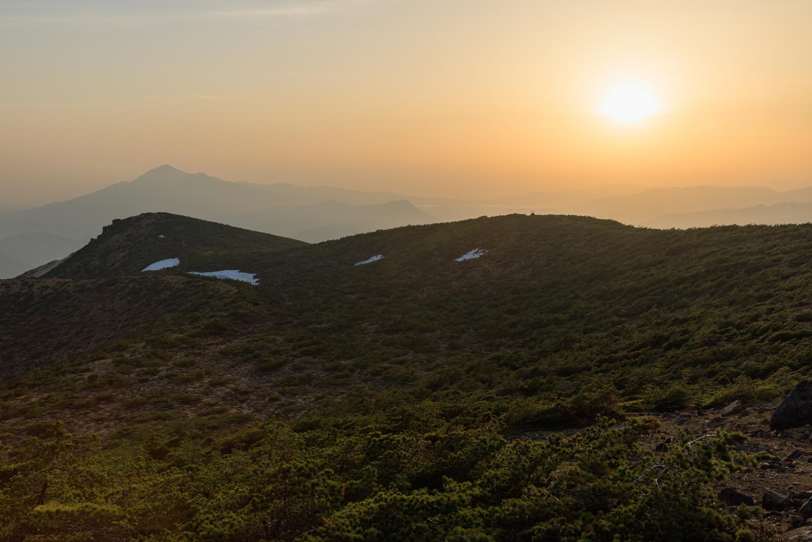 猪苗代町の鉄山から見た夕焼けの空と山並みの写真