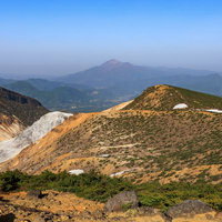 安達太良山の沼ノ平火口、残雪が点在する春の荒涼な地形の写真