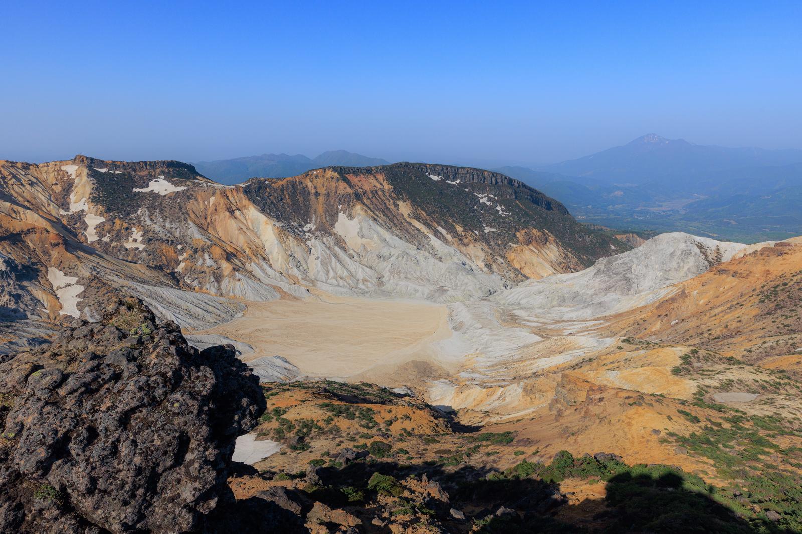 安達太良山の沼ノ平火口の荒涼とした山肌に新緑が部分的に広がる景観
