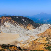 新緑が映える安達太良山の沼ノ平火口の荒涼とした地表の写真