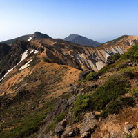矢筈森から望む安達太良山の稜線と登山道の火山岩風景の写真
