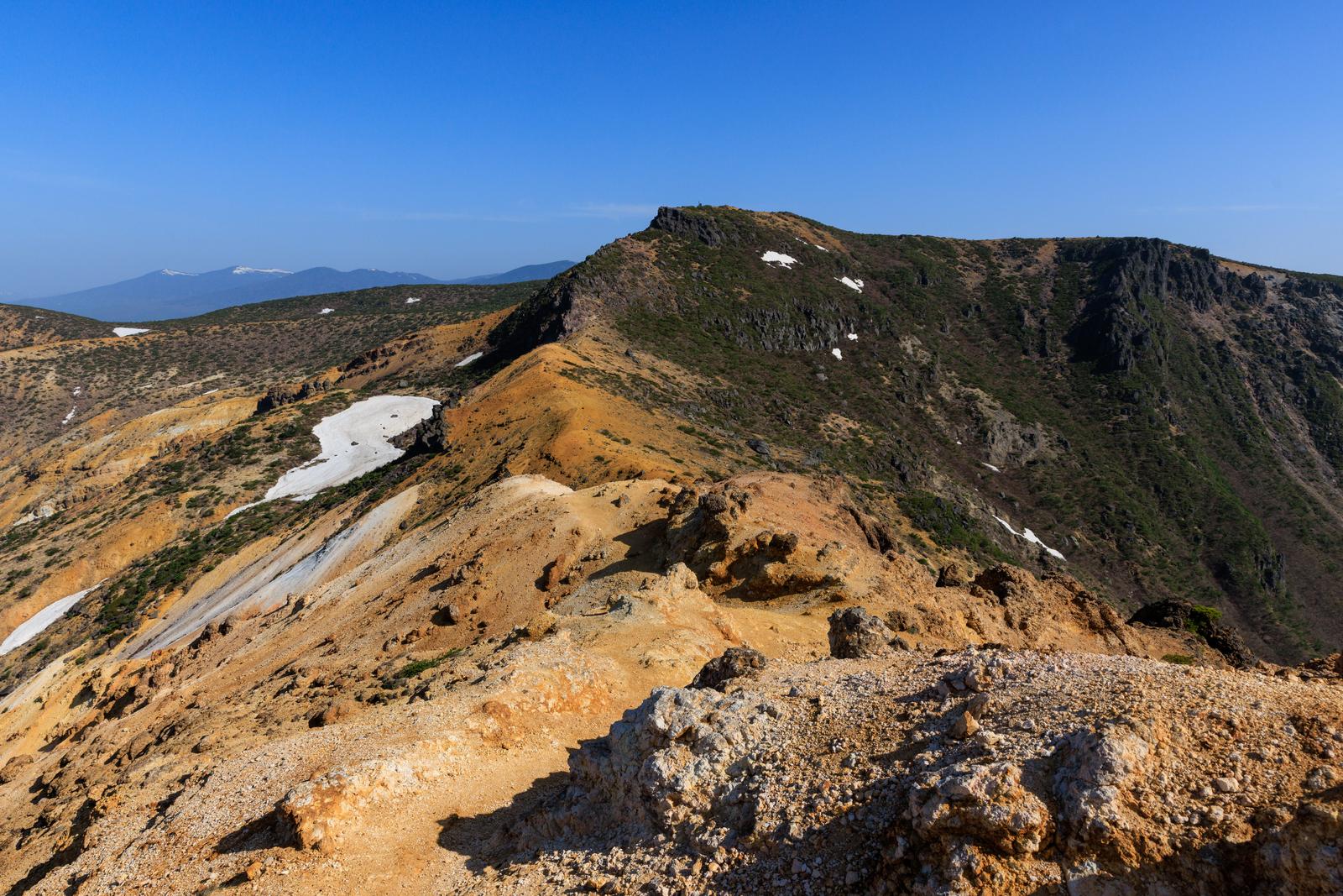 安達太良山の鉄山からの眺望。残雪と新緑の稜線が見える