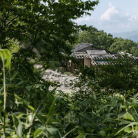 磐梯山登山道の八方台登山口付近から見える山小屋と周辺の緑の写真