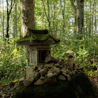 磐梯山・八方台登山口の苔むした祠とケルンの写真