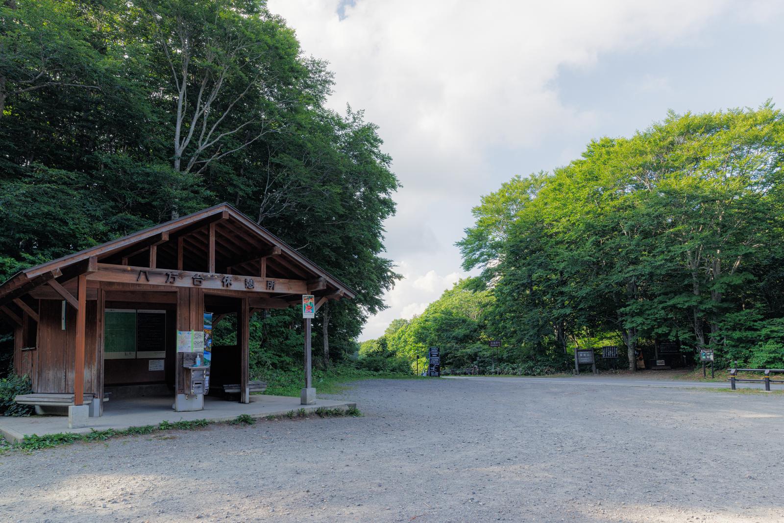 磐梯山八方台登山道沿いの木造の休憩所と周囲の緑の樹木
