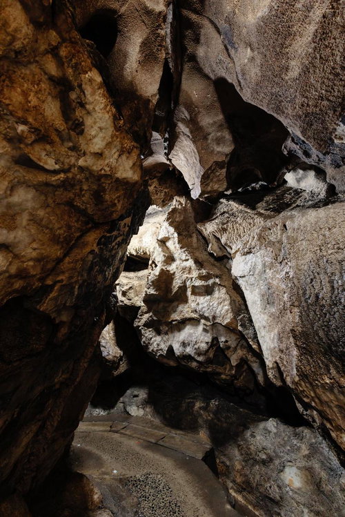 あぶくま洞の鍾乳洞内を進む狭い通路と白い鍾乳石