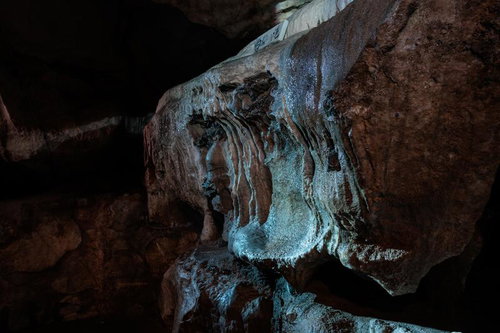 洞内の輝きを映す濡れた鍾乳石