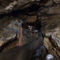 濡れた石床と鍾乳石が連なるあぶくま洞の通路の写真