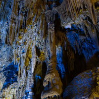 あぶくま洞の薄明ライトに照らされた黄土色の鍾乳石の写真