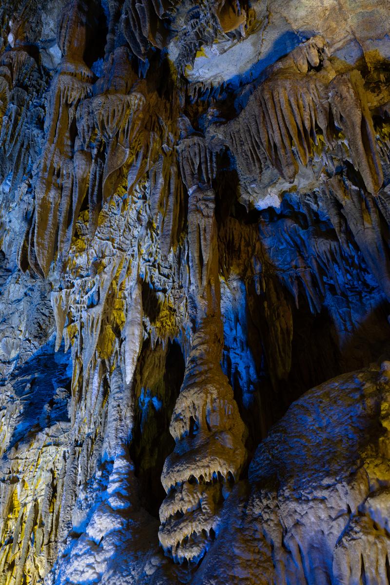 薄明ライトで照らされたあぶくま洞の黄土色の鍾乳石と青白く光る洞窟内部