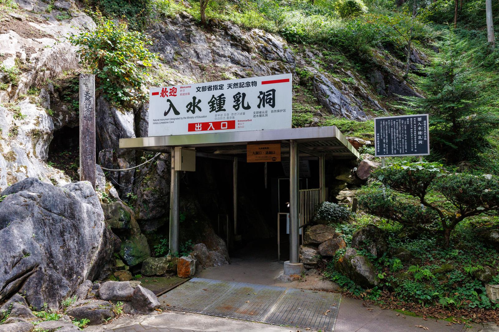 入水鍾乳洞の出入口に立つ案内小屋と緑に囲まれた洞窟入口