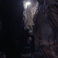 足元を照らす光と共に入水鍾乳洞の洞内通路探検の写真