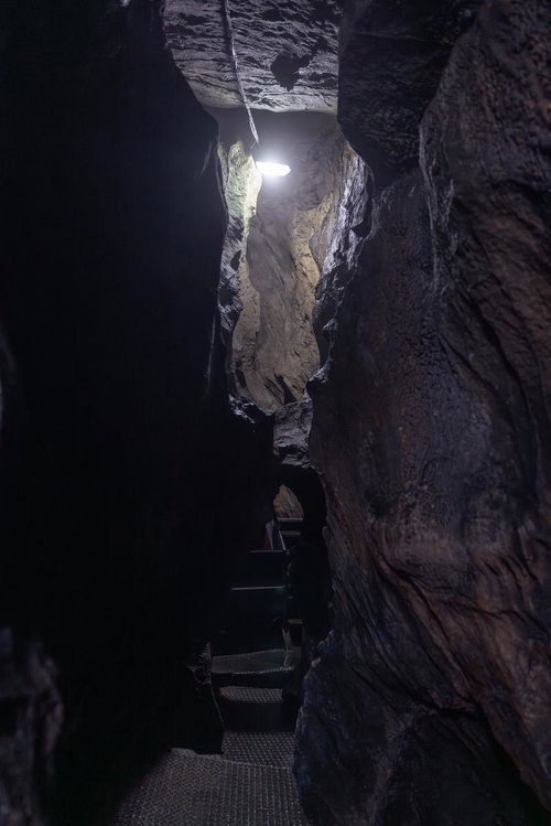 足元を照らす光と共に入水鍾乳洞の洞内通路探検