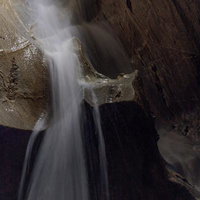 入水鍾乳洞の地底湖から落ちる水しぶきと岩壁の写真