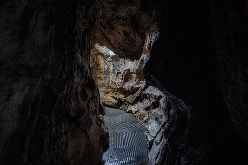 入水鍾乳洞の奥へ続く濡れた通路と石灰岩層