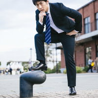 下半身で7を表現するスーツ姿の会社員男性の写真