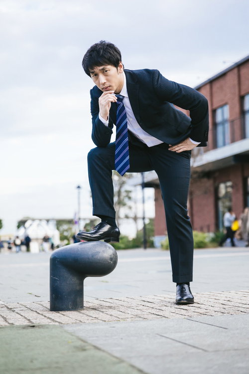下半身で7を表現するスーツ姿の会社員男性