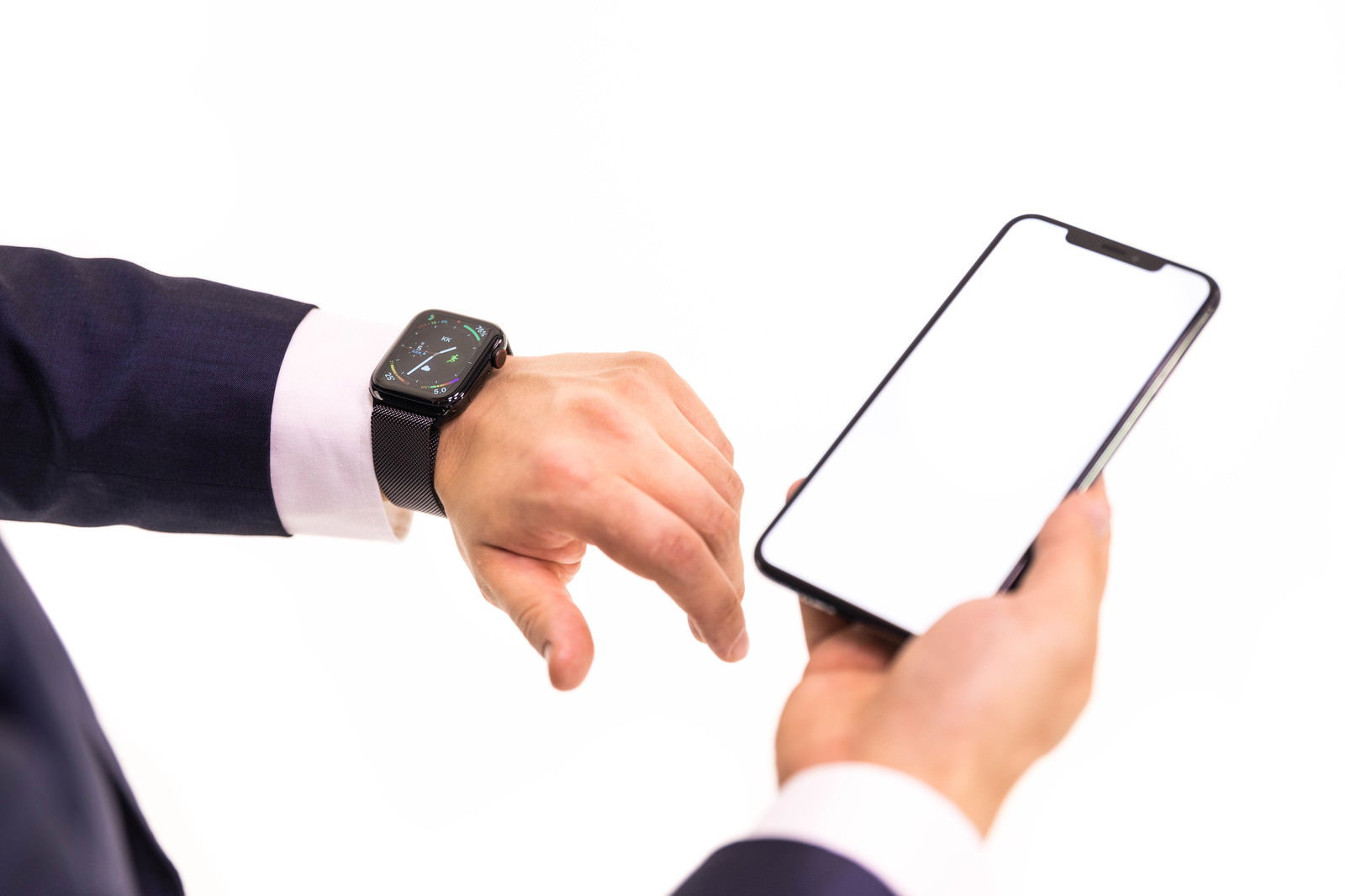 スーツの男性がスマートウォッチとスマートフォンを操作する手元