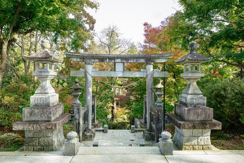 石都々古和気神社の参道に建つ石の鳥居と秋の境内