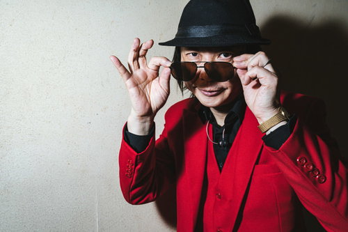 ちょっと兄ちゃん待たんかいと因縁をつけられる赤いスーツの男性