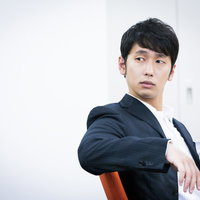 「今日はノーネクタイたい」と言いながら振り返る九州出身の男性の写真