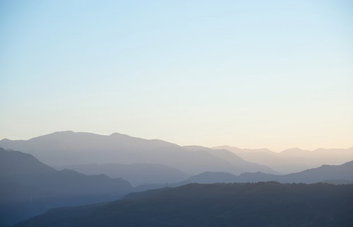 緑の山々が霧に覆われた霧深い山岳風景