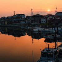 夕日に染まる彦根港の漁船の写真