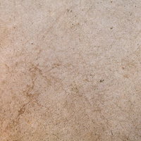 細かい粒と黒い点が散らばるベージュから茶色の日本家屋の石壁テクスチャーの写真