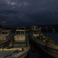 夕暮れの港に停泊する小型漁船の写真