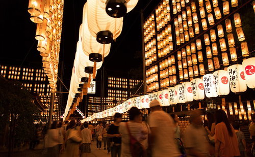 万灯祭の提灯壁と行き交う人々