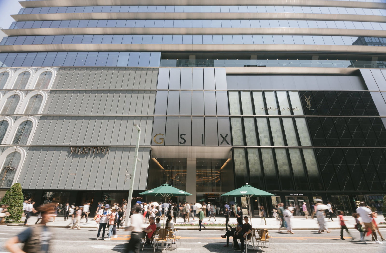 銀座シックスのグレー色のモダン建築と、入口前に集まる多くの来店客の風景
