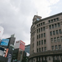 銀座の象徴、和光の時計台と東京メトロ駅前の街並みの写真