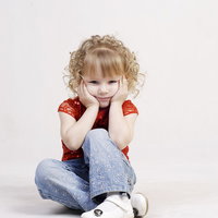 頬を両手で覆って驚く外国人の女の子の写真