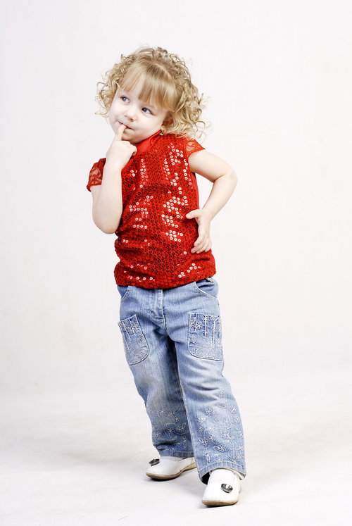 指をくわえておねだりする幼いブロンドの女の子