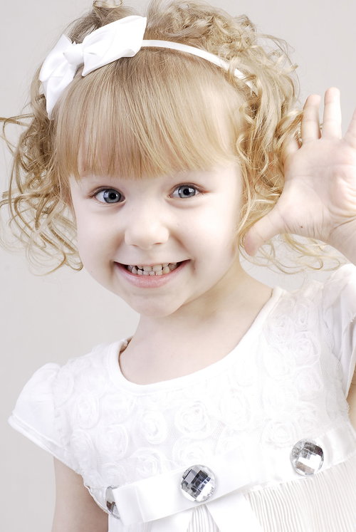 おめめパッチリのブロンドの女の子が手を上げて笑顔