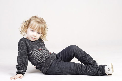 白い背景で横になってくつろぐブロンドヘアの外国人女の子