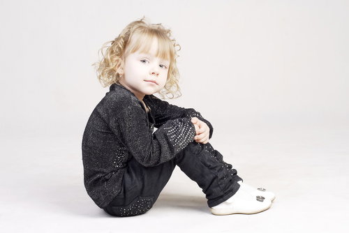 ちょこんと体育座りする子供の横顔、ひとりぼっちで待つ