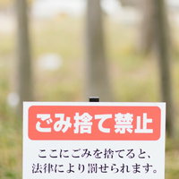 ごみ捨て禁止の赤い警告看板、法律違反の注意書き表記の写真